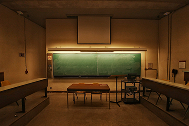 dark classroom with green chalkboard at front